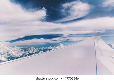 Blurred of wing with clounds background.View from inside the plane.Used film filter for old tone color.