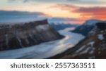 Blurred Winter Background of Majestic Snow-Capped Cliffs Overlooking Frozen River