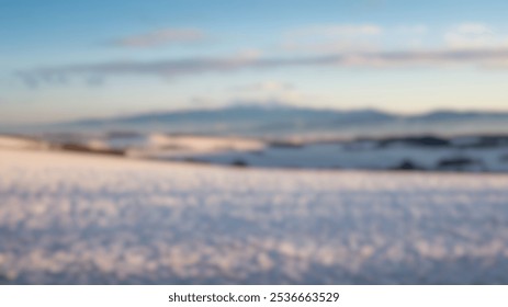 Blurred Winter Background of Snow-Covered Fields Stretching Towards Distant Mountains - Powered by Shutterstock