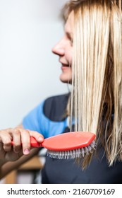 Blurred Woman Combing Wet Hair With Massage Comb On White Background.