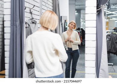 Blurred Woman Looking At Mirror In Dressing Room In Second Hand