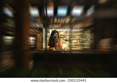 blurred woman use phone in coffee shop, Girl texting on the smart phone in a restaurant terrace with an unfocused background