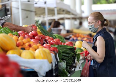 Blurred Woman Wear Face Mask Is Buying Fresh Fruits And Vegetables On A Farmer Market  In Sofia, Bulgaria On July 22, 2020