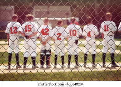 Blurred youth baseball background, children in a row with their hats off at the beginning of a game.