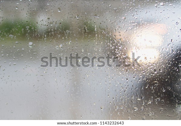 The blurring of water droplets on the glass\
surface due to heavy rain in the rainy season.\
Rain drops on the\
surface of the glass outside, the restaurant next to the road can\
also see the car passed.