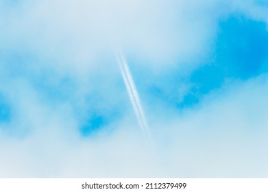 Blurry abstract background with clouds and aircraft condensation trail