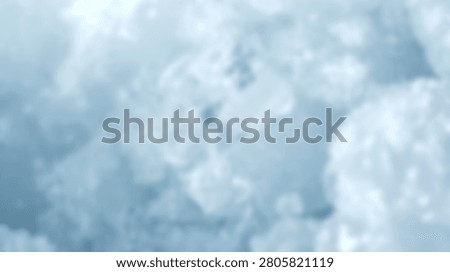 A blurry abstract background featuring soft shades of blue and white resembling clouds or smoke