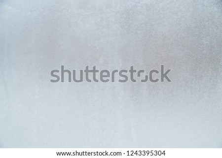 Blurry abstract background of foggy condensation on window glass natural surface, cold and ice on glass