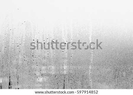 Blurry abstract background of foggy condensation on window glass natural surface. Grey glass texture wallpaper