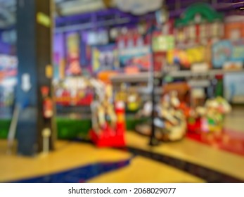 Blurry Abstract Background Of Indoor Kid Game Zone Inside Departement Store. Bokeh Image Of Arcade Game With Vintage Tone.

