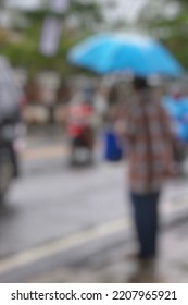 Blurry Abstract Photo Of Street Photography, People Using Umbrella In Urban Area During Rainy Season.