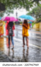 Blurry Abstract Photo Of Street Photography, People Using Umbrella In Urban Area During Rainy Season.