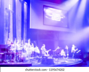 Blurry Abstract Worship Band And The Choir At Bible Church In Texas, USA. Dark Background, Smoke, Concert Spotlights For Christian Concept. Worship Lyric Projection