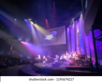 Blurry Abstract Worship Band And The Choir At Bible Church In Texas, USA. Dark Background, Smoke, Concert Spotlights For Christian Concept. Worship Lyric Projection