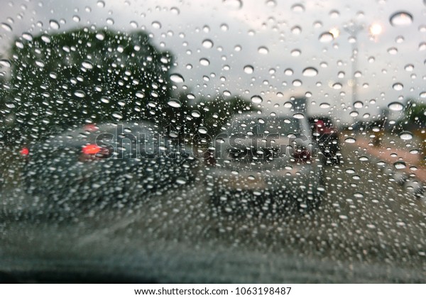 blurry background with raindrop on car windows in\
raining day