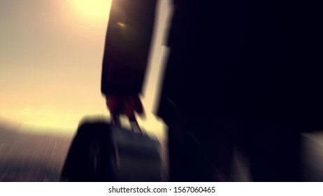 Blurry Background From Silhoutte Of Young Businessman Holding Briefcase And Look Town View As A Market To Be Conquered In Future.