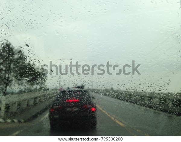 Blurry background wallpaper traffic on the
bridge with raindrop view from
windscreen