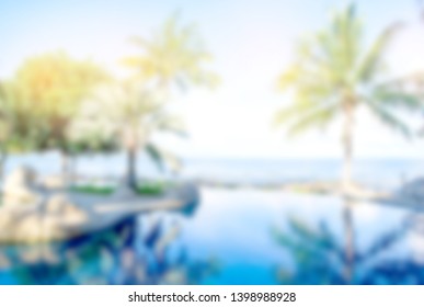 Blurry Blackground Morning Time At Swimming Pool And The Blue Sea With Palm,coconut Trees With Background White Clouds And Blue Sky,  Peacful And Realax, Tropical Resort In Asia.