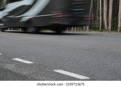 Blurry Class C Motor Home RV Speeds By On Rural Two Lane Highway In A Wyoming National Forest In Between Yellowstone National Park And Grand Teton National Park