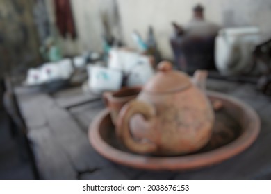 Blurry Close Up View Of Broken And Dirty Tea Pot, Cups And Mugs Abandoned On Wooden Table. Use For Background Or Backdrop. No People.