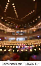 Blurry Colorful Lights Shining In A Large Room. The Predominance Of Yellow Light. Bokeh Lights, Defocused, Great For Backgrounds And Wallpapers.