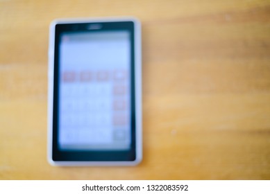 Blurry defocused close up of tablet pc mockup touch screen device laying on wooden desk. Modern wireless internet gadget flat lay topview copyspace. Work, watching video, game fun, texting design