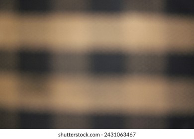 A blurry dreamy view of an alternating pattern of black and beige squares.