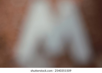 A blurry dreamy view of the letter m in beige and brown. - Powered by Shutterstock