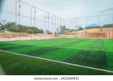 Blurry empty outdoor football court. Defocused empty outdoor soccer football field with green grass.mini soccer field. - Powered by Shutterstock