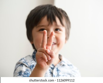 Blurry Face Of Boy Looking Showing His Fingers At Camera,Selective Focus Of Kid Primary School Counting Number Second,Cute Kid Showing Numbers Two With Fingers,Education Or Toddler Development Concept