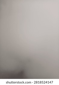 A blurry, featureless image with a smooth gradient transition from light grey to dark grey.
