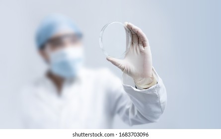 Blurry Female Scientist Holding Empty Petri Dish