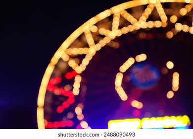 Blurry Giant Ferris wheel (Bianglala), with colorful lights. Bokeh lights. Party lights, out of focus, noise, copy space. - Powered by Shutterstock