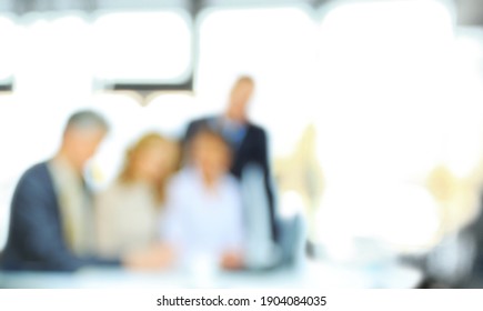 blurry image. background image of a group of young people at a meeting in a conference room
