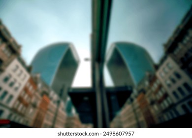 A blurry image of buildings in a city, with a tall building on the right and another tall building on the left, partially visible.  Both buildings have a curved, rounded roof.  The image is taken at a - Powered by Shutterstock