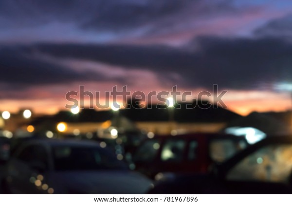 Blurry image of busy car park on\
the top of buliding with dramatic sky in evening in the\
winter