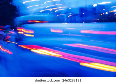 A blurry image of a busy street with cars and a bus. The image has a sense of motion and energy, as if it were captured in a time-lapse. The blue and red colors of the cars - Powered by Shutterstock