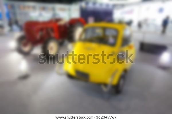 blurry image of  cars in\
motor show