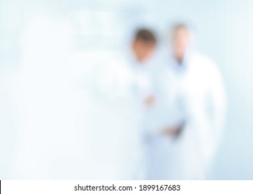 Blurry Image Of Doctors Standing In The Hospital Corridor.