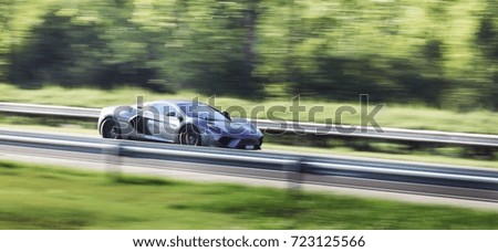 Blurry image of fast driving super car on highway