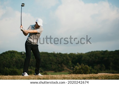 blurry image of golfer take the swing shot with a strong stance.
