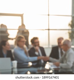 Blurry Image Of A Handshake Of Business People At A Meeting In The Office.