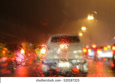 Blurry Image Of Inside Cars With Bokeh Lights With Traffic Jam And Raining On Night Time For Background Usage.