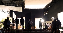 Blurry Image Of Making Movie Video In Big Production Studio And Film Crew Team Shooting Or Recording By Professional Digital Camera And Lighting Set Equipment.