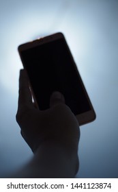 Blurry Image Of Man Hand Holding Phone In Low Lights,can Be Use For Terror Or Mysterious Caller