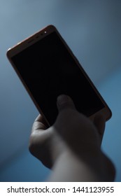 Blurry Image Of Man Hand Holding Phone In Low Lights,can Be Use For Terror Or Mysterious Caller