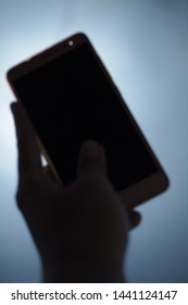 Blurry Image Of Man Hand Holding Phone In Low Lights,can Be Use For Terror Or Mysterious Caller