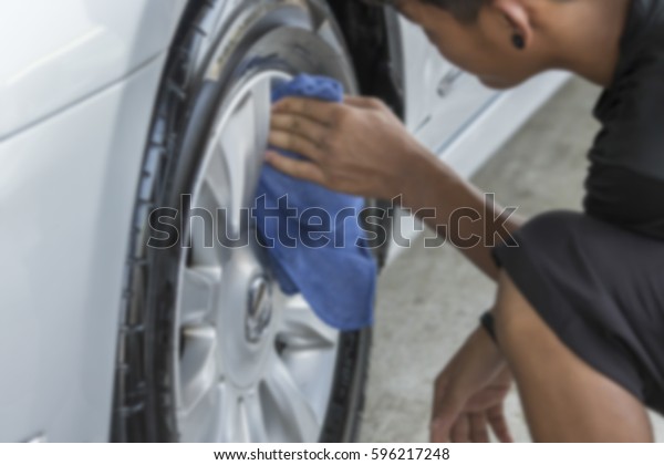 Blurry image, Man was wiping car\
wheel with hand and microfiber cloth, Car cleaning, Car\
washing