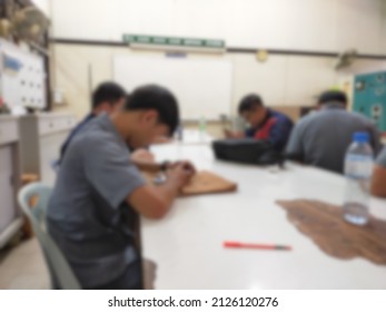 Blurry Image Of People Sitting In Class In The Classroom Of A Vocational College.