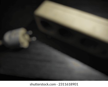 blurry image, white power plug on black background - Shutterstock ID 2311618901